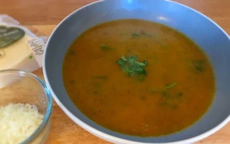 carrot and coriander soup with cheese and chopped coriander